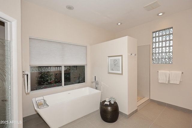 full bathroom with baseboards, walk in shower, tile patterned floors, and a freestanding tub