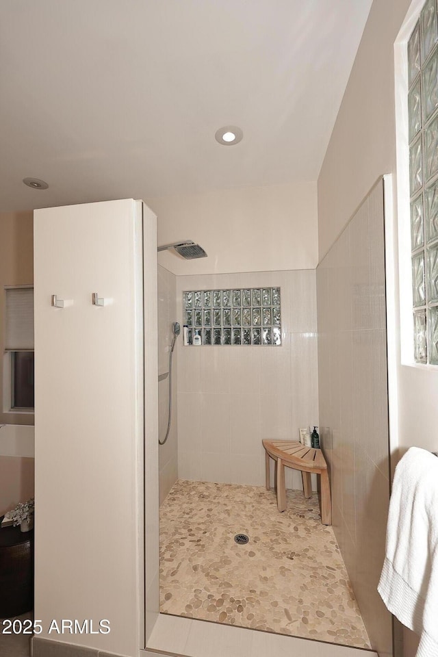 full bath featuring tiled shower, visible vents, and recessed lighting