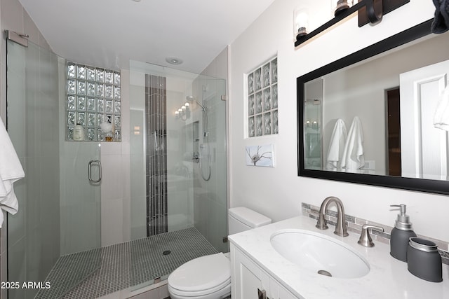 bathroom featuring a stall shower, vanity, and toilet