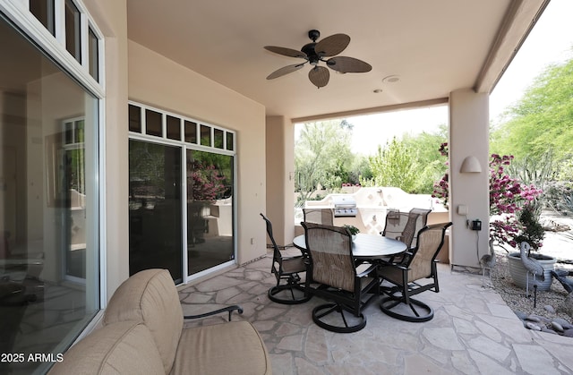 view of patio with area for grilling, outdoor dining area, and a ceiling fan