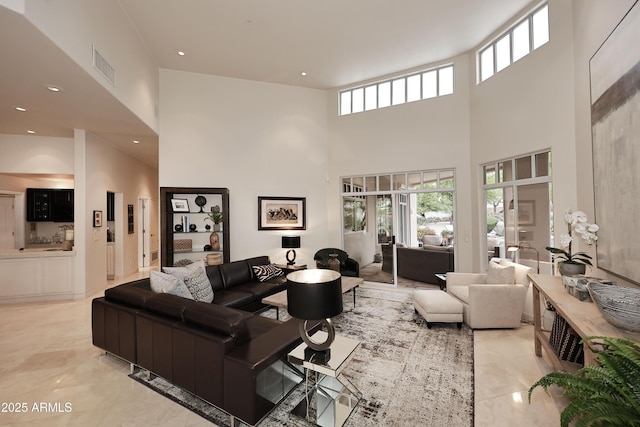 living area featuring marble finish floor, a high ceiling, visible vents, and recessed lighting