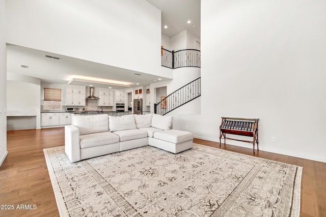3417 E Los Gatos Dr, Phoenix, AZ 85050 - living area featuring light wood finished floors, stairway, recessed lighting, and a towering ceiling
