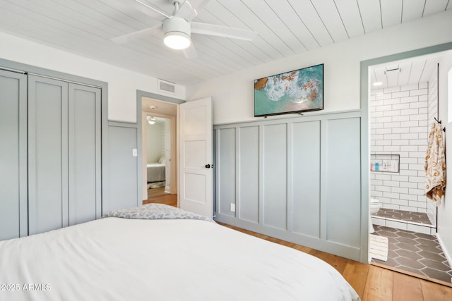 653 W Inglewood St, Mesa, AZ 85201 - bedroom with wood ceiling, wood finished floors, a wainscoted wall, connected bathroom, and a decorative wall