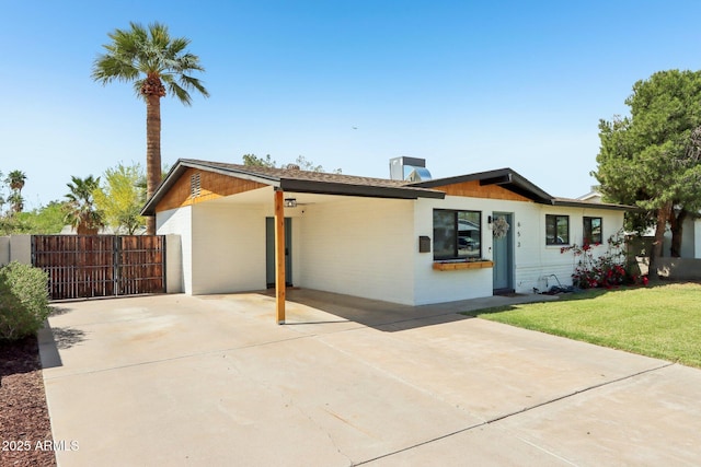 653 W Inglewood St, Mesa, AZ 85201 - ranch-style house with a front lawn, fence, a chimney, driveway, and a carport