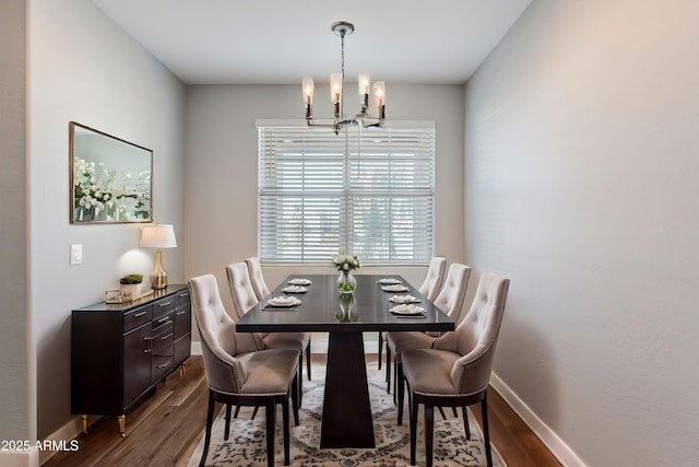 dining room with hardwood / wood-style floors and an inviting chandelier