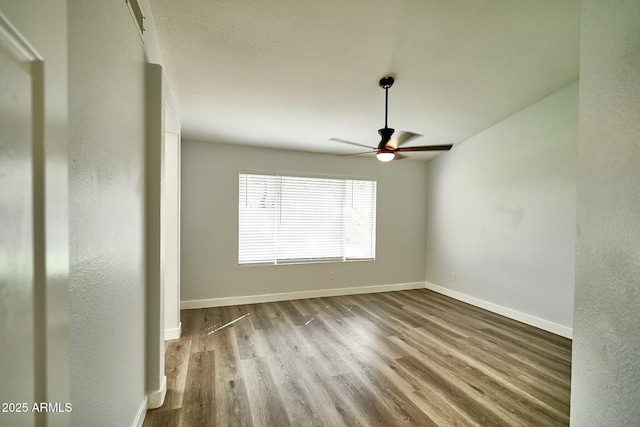 unfurnished room with ceiling fan, light wood-type flooring, and baseboards