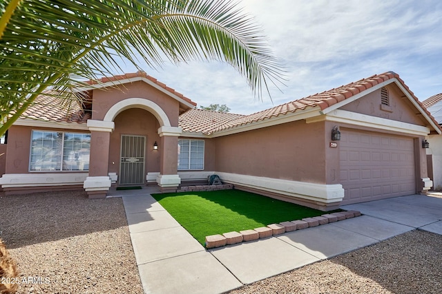 mediterranean / spanish-style house featuring driveway, an attached garage, a tiled roof, and stucco siding