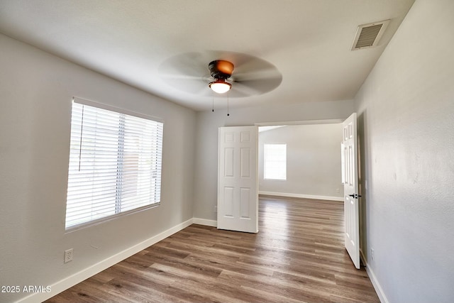 unfurnished bedroom with dark wood-style floors, baseboards, visible vents, and ceiling fan