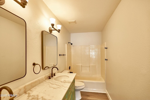 full bathroom with toilet, vanity, shower / tub combination, wood finished floors, and baseboards