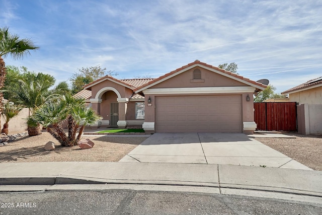 view of front of house featuring a garage, driveway, a tiled roof, and stucco siding