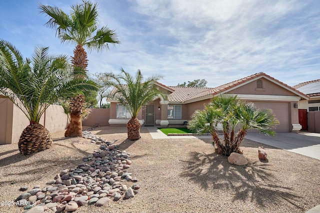 view of front of home with an attached garage, fence, a tile roof, driveway, and stucco siding