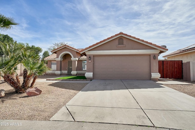 view of front of home with driveway, a tiled roof, an attached garage, and stucco siding