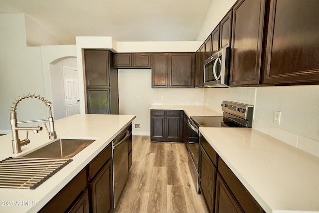 kitchen with stainless steel appliances, light countertops, and light wood-style floors