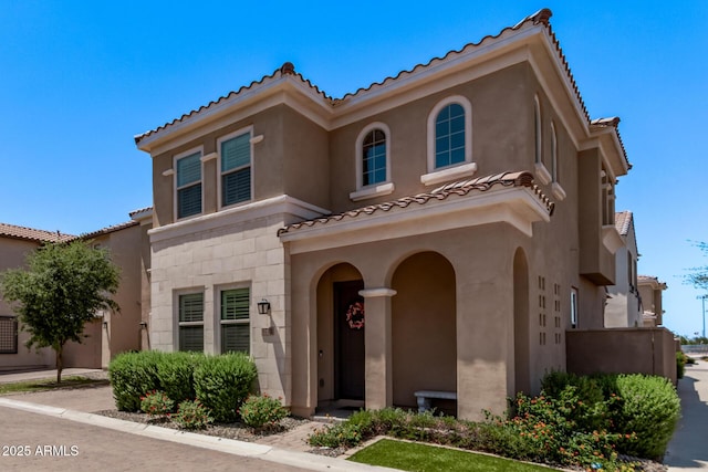 mediterranean / spanish house with a tile roof and stucco siding