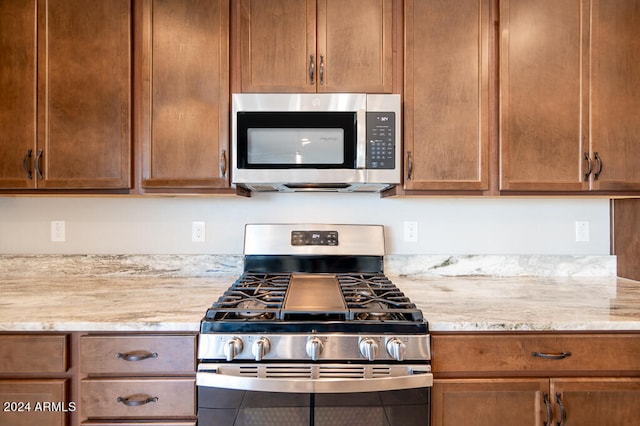 kitchen featuring appliances with stainless steel finishes and light stone countertops