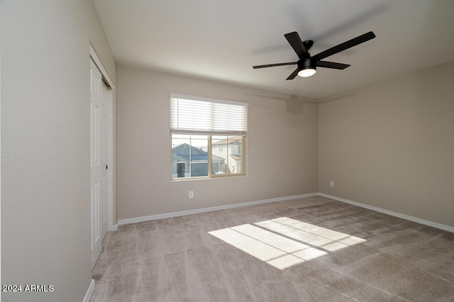 unfurnished room with ceiling fan and light carpet