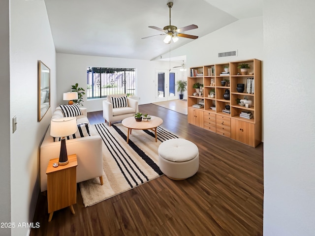 living room with visible vents, lofted ceiling, wood finished floors, and a ceiling fan