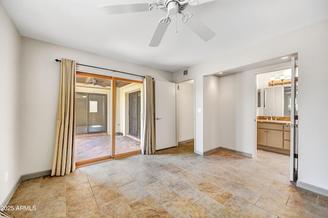 37801 N Cave Creek Rd Unit 13, Cave Creek, AZ 85331 - unfurnished bedroom featuring access to exterior, light stone finish flooring, ensuite bath, and a ceiling fan