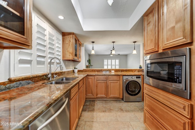 37801 N Cave Creek Rd Unit 13, Cave Creek, AZ 85331 - kitchen featuring washer / clothes dryer, appliances with stainless steel finishes, brown cabinetry, stone countertops, and glass insert cabinets