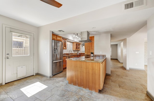 37801 N Cave Creek Rd Unit 13, Cave Creek, AZ 85331 - kitchen featuring stainless steel refrigerator with ice dispenser, island exhaust hood, a peninsula, stone counters, and black electric cooktop