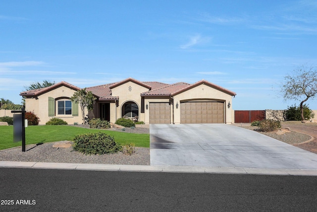 mediterranean / spanish home featuring a garage and a front lawn