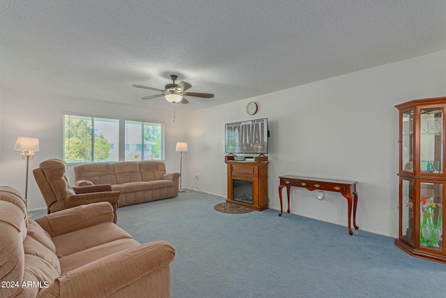 carpeted living room with ceiling fan and a textured ceiling