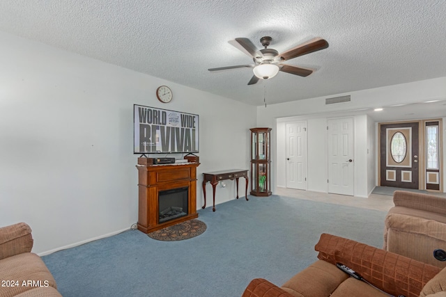 living room with light carpet, a textured ceiling, and ceiling fan