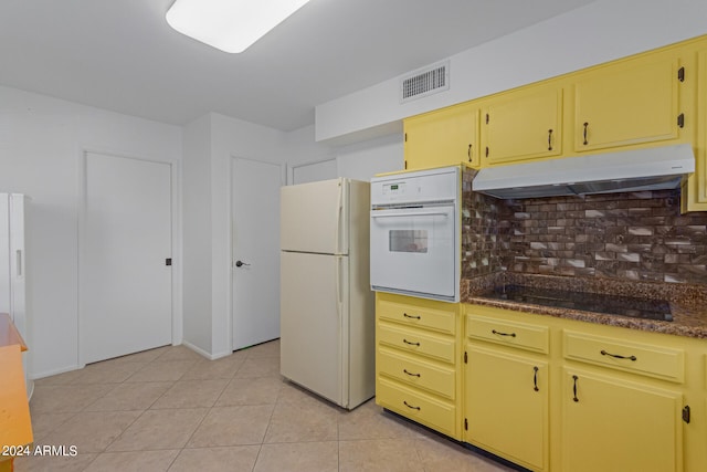 kitchen with light tile patterned flooring, white appliances, and tasteful backsplash