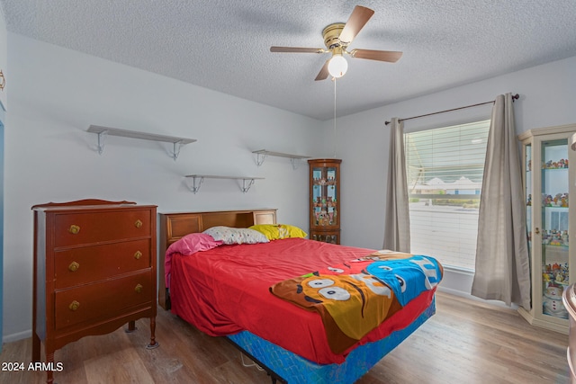 bedroom featuring hardwood / wood-style floors, a textured ceiling, and ceiling fan