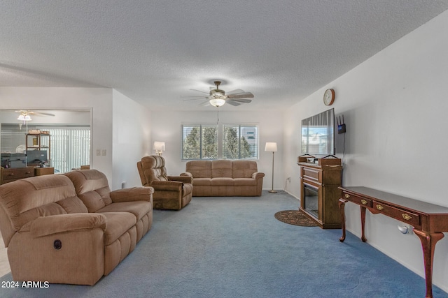 living room featuring ceiling fan, a textured ceiling, and carpet floors