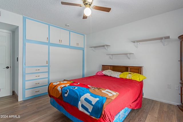 bedroom with a textured ceiling, dark wood-type flooring, and ceiling fan