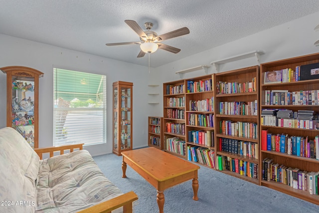 sitting room featuring a textured ceiling, light colored carpet, and ceiling fan