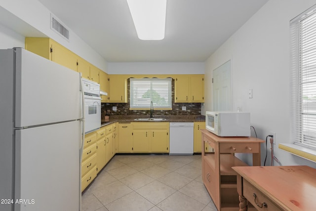 kitchen with backsplash, sink, white appliances, and light tile patterned floors