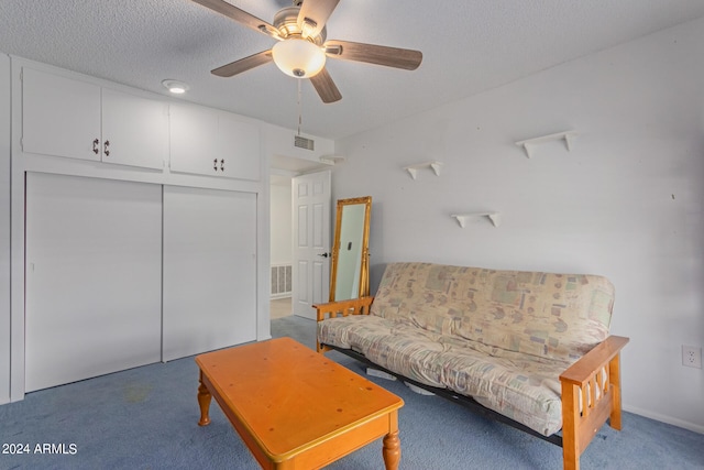 carpeted living room with a textured ceiling and ceiling fan