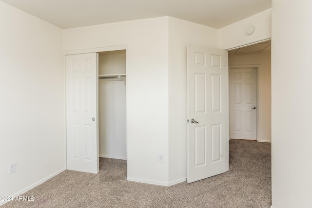 unfurnished bedroom with light carpet and a closet