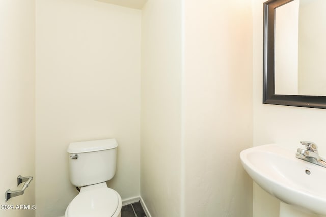 bathroom with sink, toilet, and tile patterned flooring