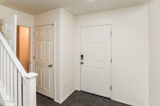 entrance foyer with dark tile patterned floors