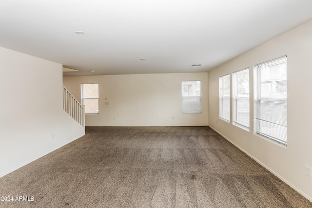 spare room with a wealth of natural light and carpet floors