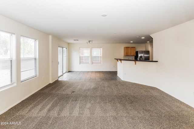 unfurnished living room featuring dark colored carpet