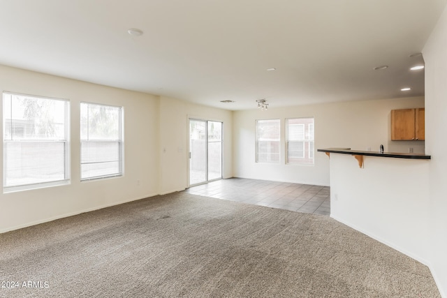 unfurnished living room with plenty of natural light and light carpet