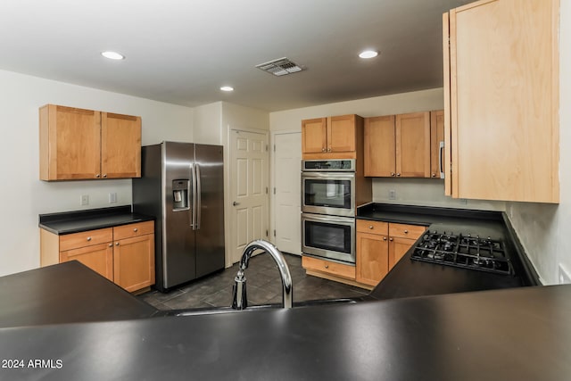 kitchen featuring sink, appliances with stainless steel finishes, and dark tile patterned floors