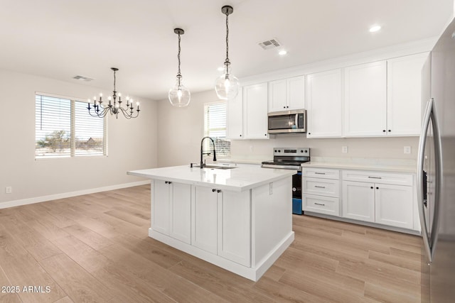 kitchen featuring hanging light fixtures, visible vents, appliances with stainless steel finishes, and white cabinets