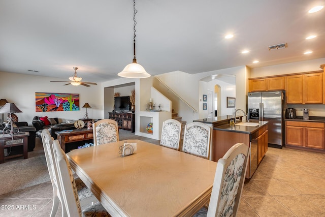 tiled dining space with ceiling fan and sink