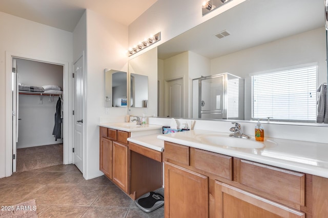 bathroom featuring tile patterned flooring, vanity, and an enclosed shower