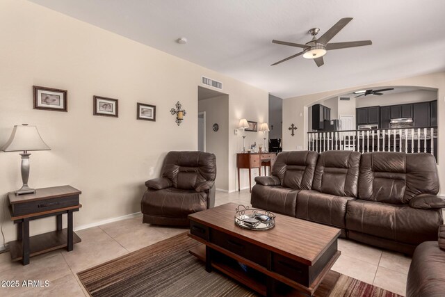 4834 E Robin Ln, Phoenix, AZ 85054 - living room with ceiling fan, arched walkways, light tile patterned floors, and baseboards