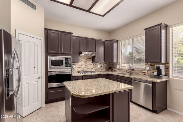 4834 E Robin Ln, Phoenix, AZ 85054 - kitchen featuring stainless steel appliances, under cabinet range hood, open shelves, a sink, and backsplash