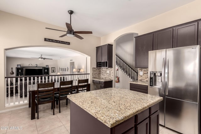 4834 E Robin Ln, Phoenix, AZ 85054 - kitchen featuring stainless steel fridge, ceiling fan, tasteful backsplash, light stone countertops, and light tile patterned floors