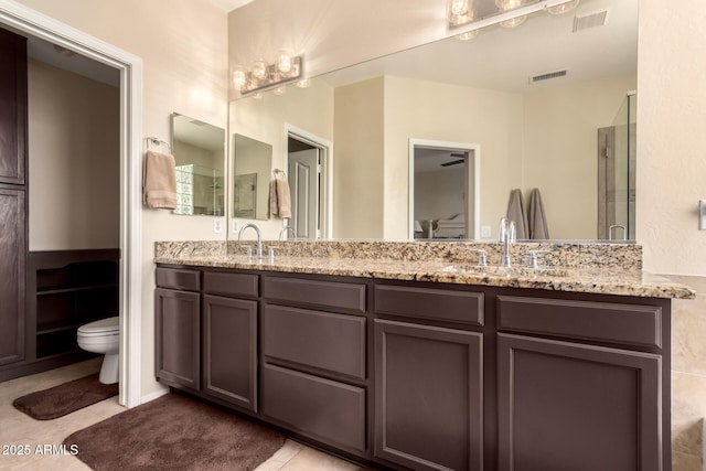 4834 E Robin Ln, Phoenix, AZ 85054 - bathroom featuring toilet, a stall shower, double vanity, and tile patterned floors