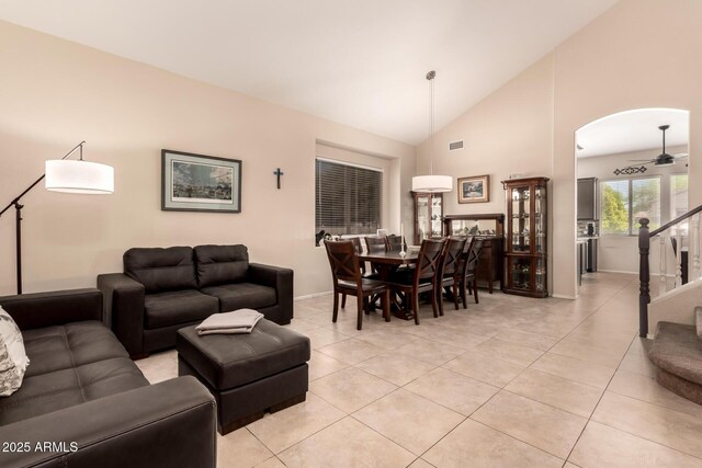4834 E Robin Ln, Phoenix, AZ 85054 - living room with stairs, light tile patterned flooring, baseboards, ceiling fan, and high vaulted ceiling
