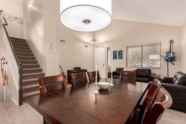 4834 E Robin Ln, Phoenix, AZ 85054 - dining space with high vaulted ceiling, light tile patterned floors, and stairs